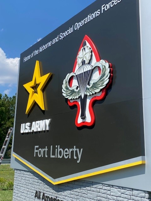 A man stands next to wall signage for the headquarters of the U.S. Army Forces Command.