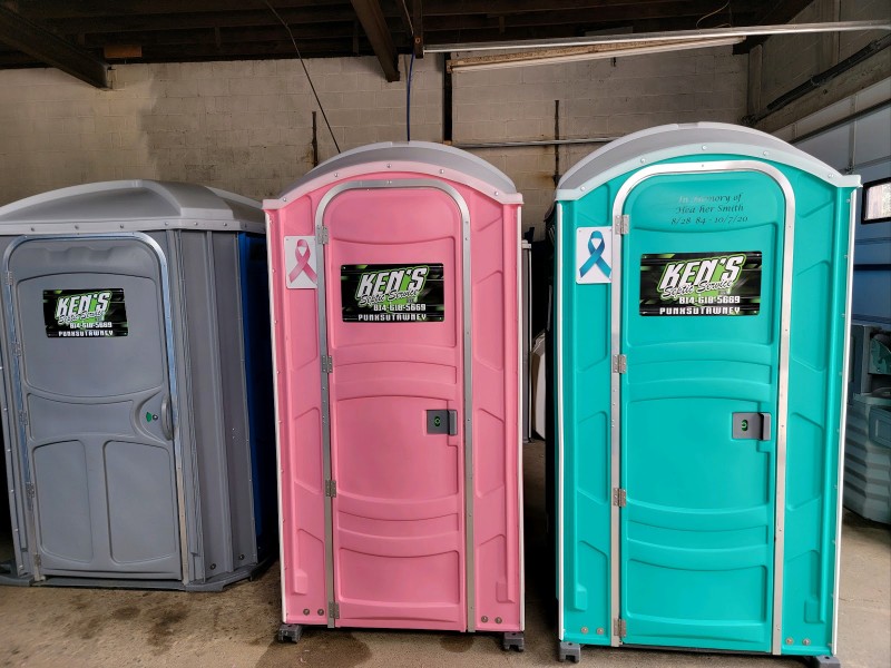 Three colorful portable toilets.