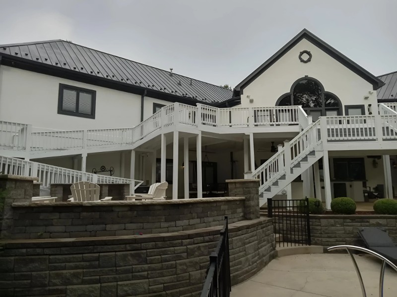 A home with a large, two-level deck with stairway freshly painted.