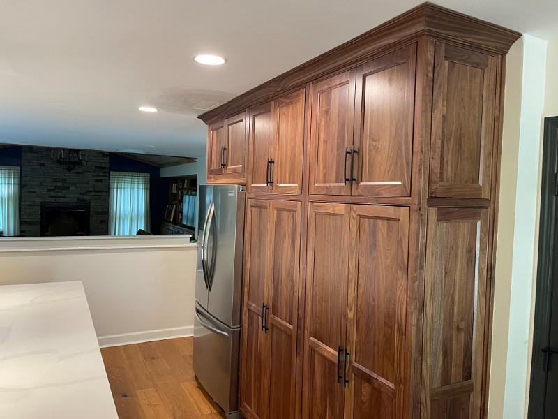 Wooden kitchen cabinets surround a refrigerator.