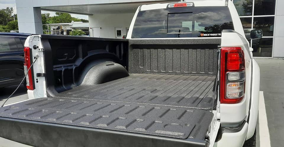 White truck with a freshly installed bedliner.