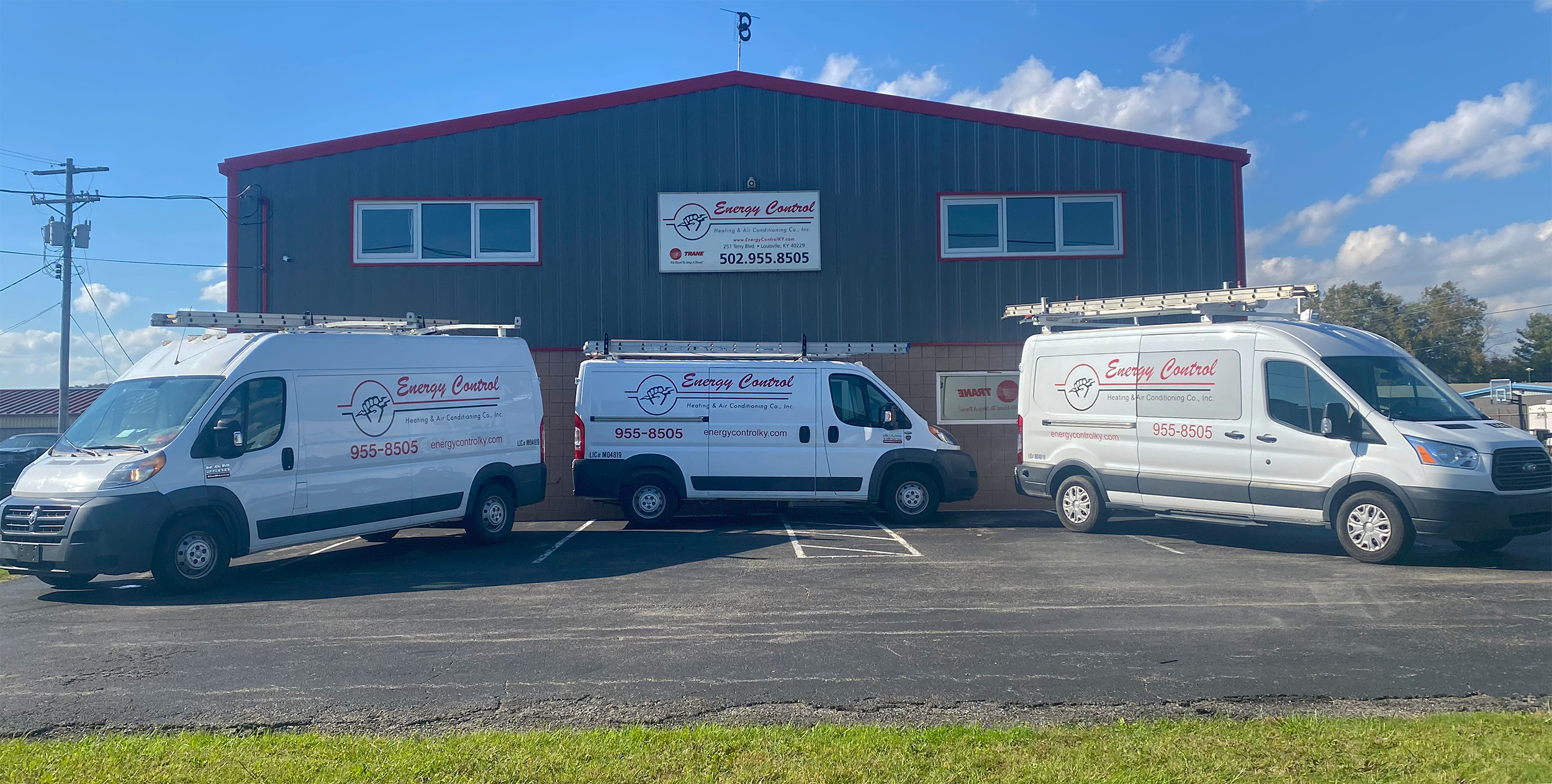 The business office of Energy Control Heating & Air conditioning with three service vans sitting in front of the building.