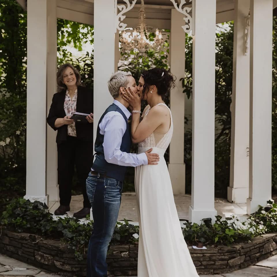 A man and wife kiss at their wedding ceremony.