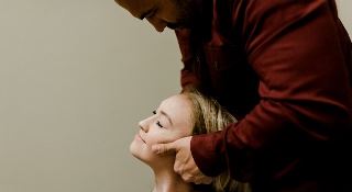 A chiropractor adjusts a lady’s neck.