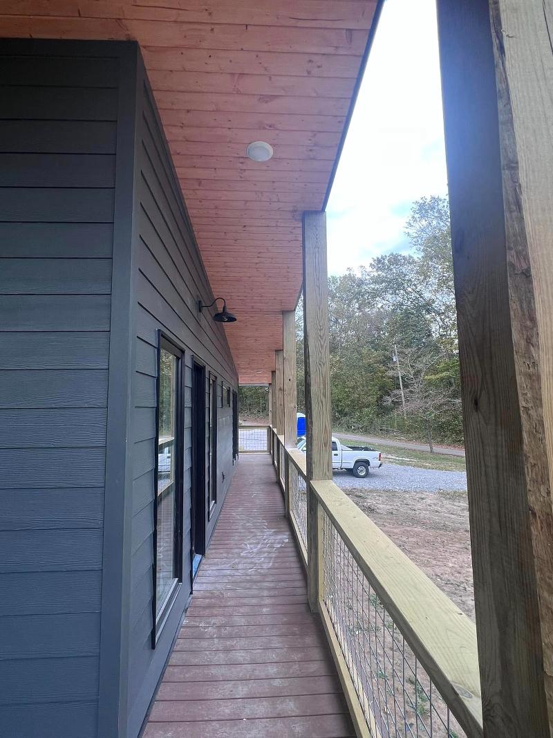 Dark grey house with deck.