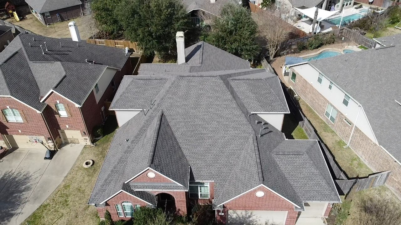 Single story home with multi-layered grey shingle roof.