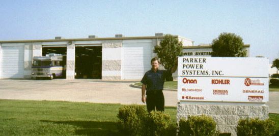 A man stands next to a Parker Power Systems sign.