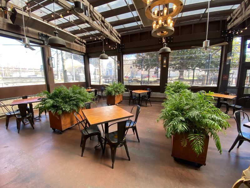 patio space with tables, chairs, greenery