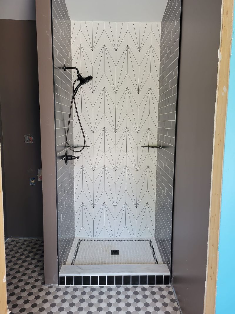 A modern tile shower with tile flooring.
