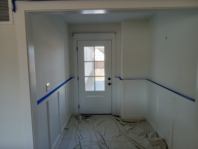 A home’s entry hallway taped off for painting.