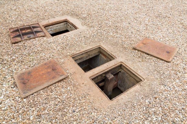 Three covers lay on the ground near storm drains.