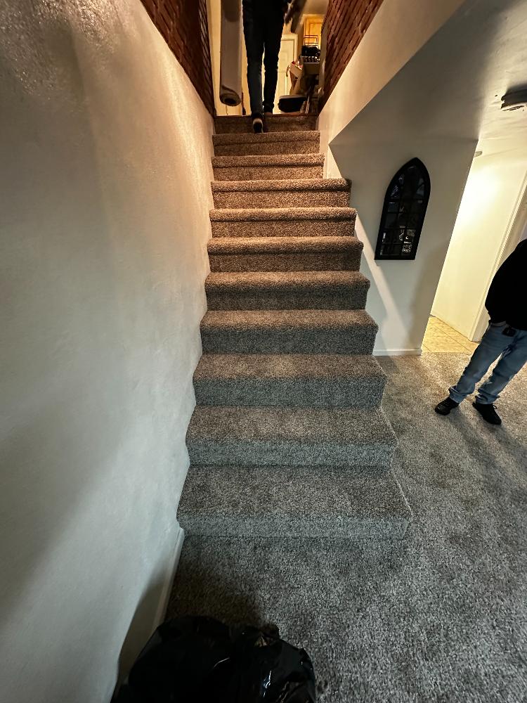 Staircase with dark grey carpet.