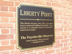 An informational plaque on a brick wall for Liberty Point.