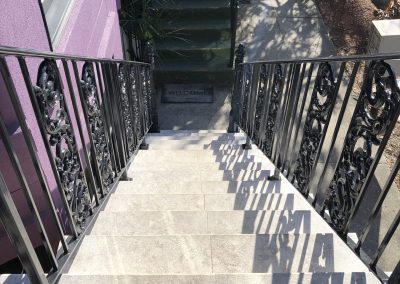 Iron railing along an outdoor staircase.