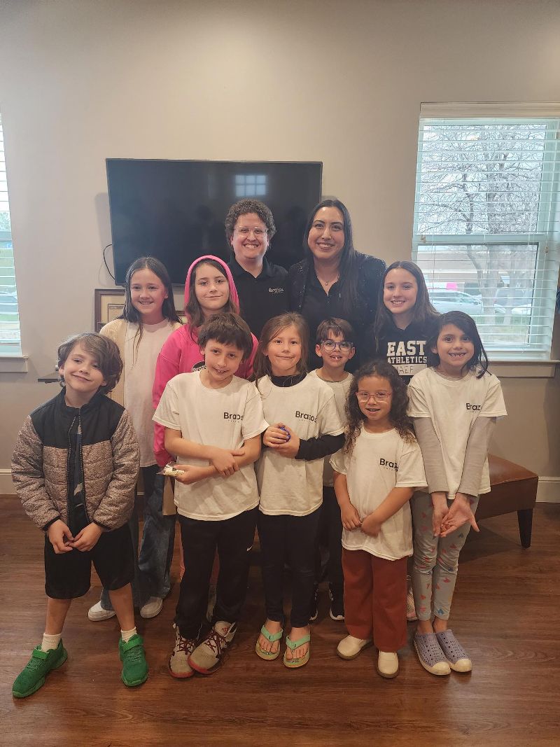 Two instructors pose with a group of students after a recital.