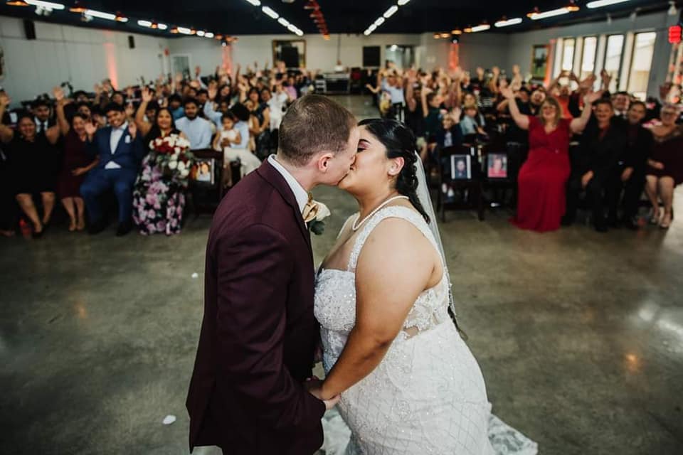 A bride and groom kiss at their wedding ceremony.