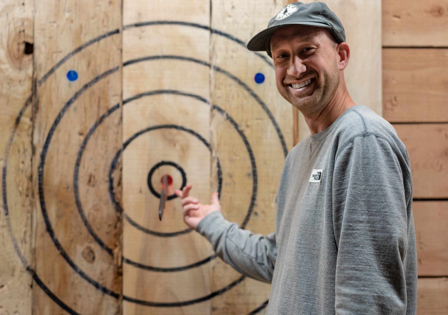 A man points to his knife in a bullseye.