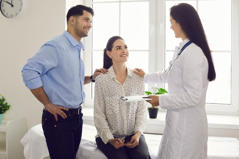 Clinician talking to young husband and wife. 