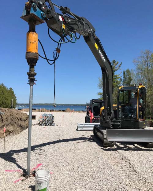 Deep Foundation Repair uses heavy machinery to drive helical piers into the ground.