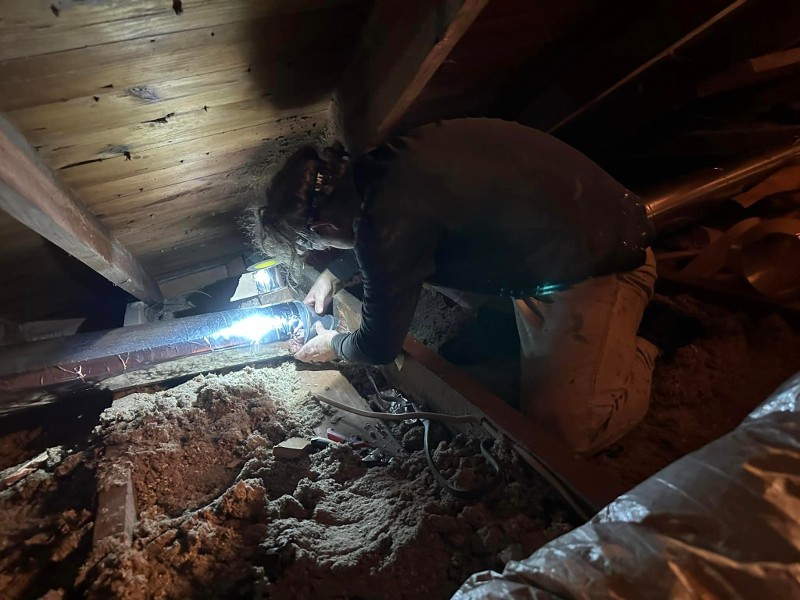 Man working on insulation in an attic