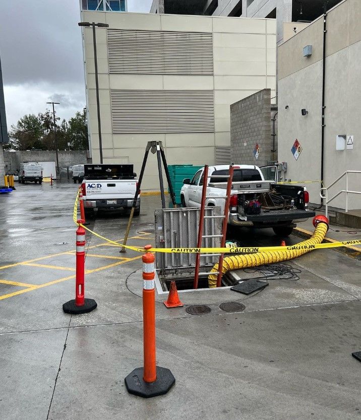 A white pickup truck sets next to equipment inserted into a septic system.