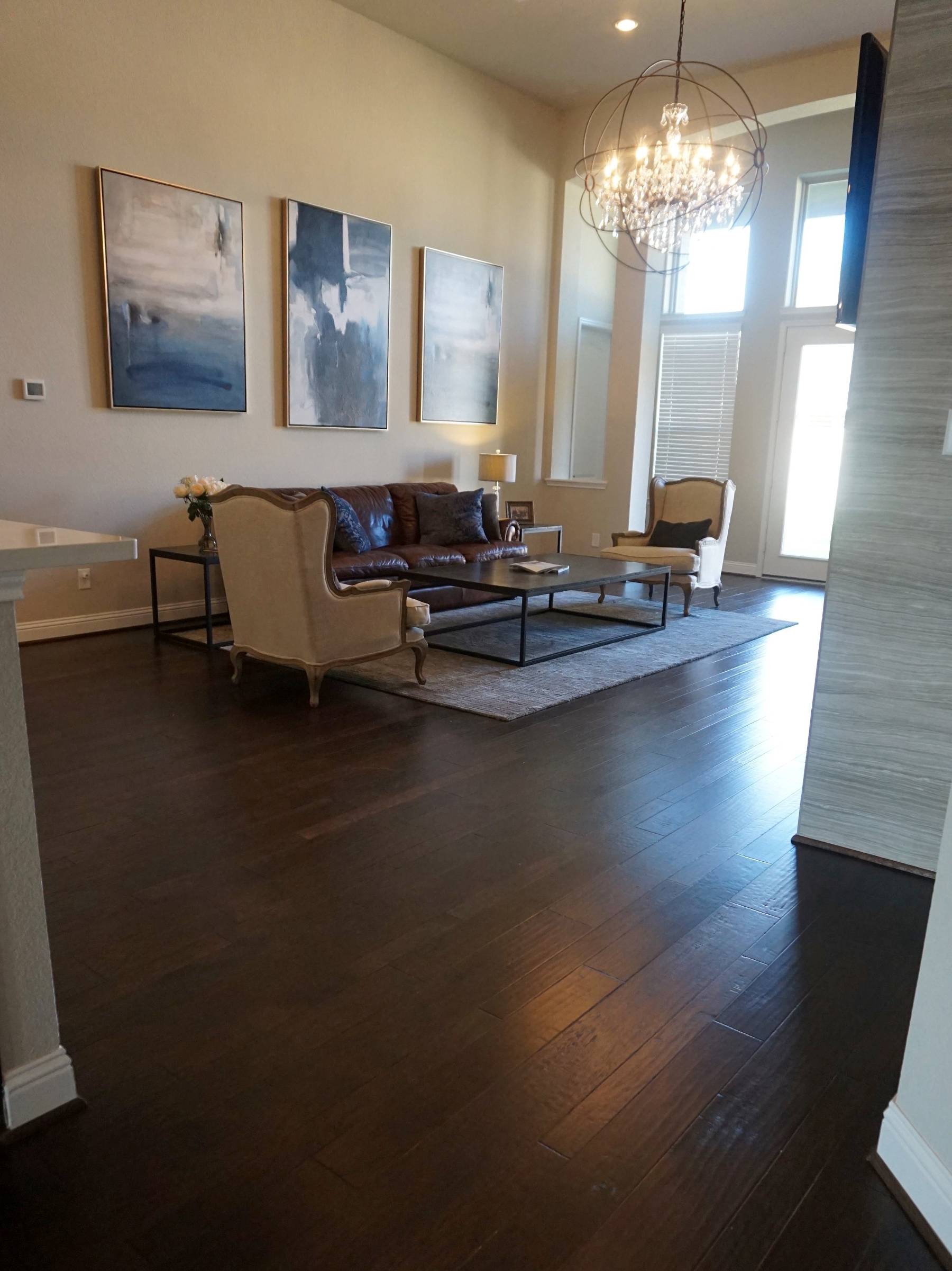 A living room scene with dark hardwood flooring.