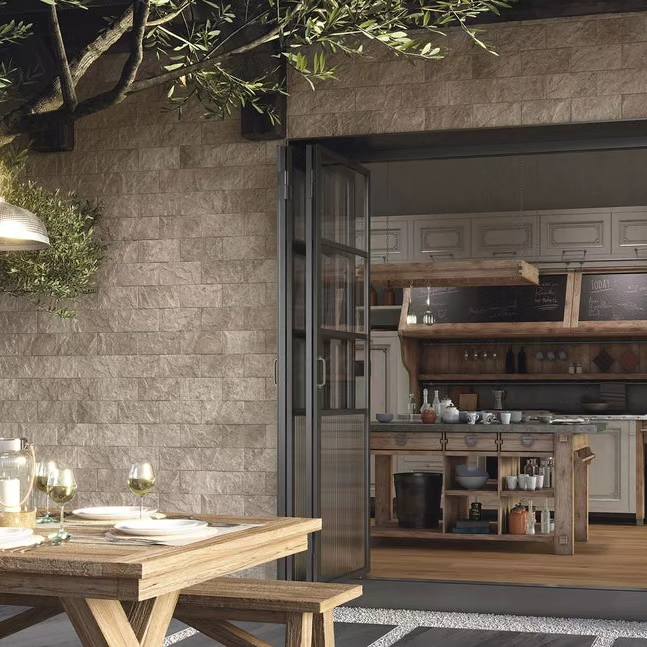 A stone patio wall with hurricane doors leading to a kitchen