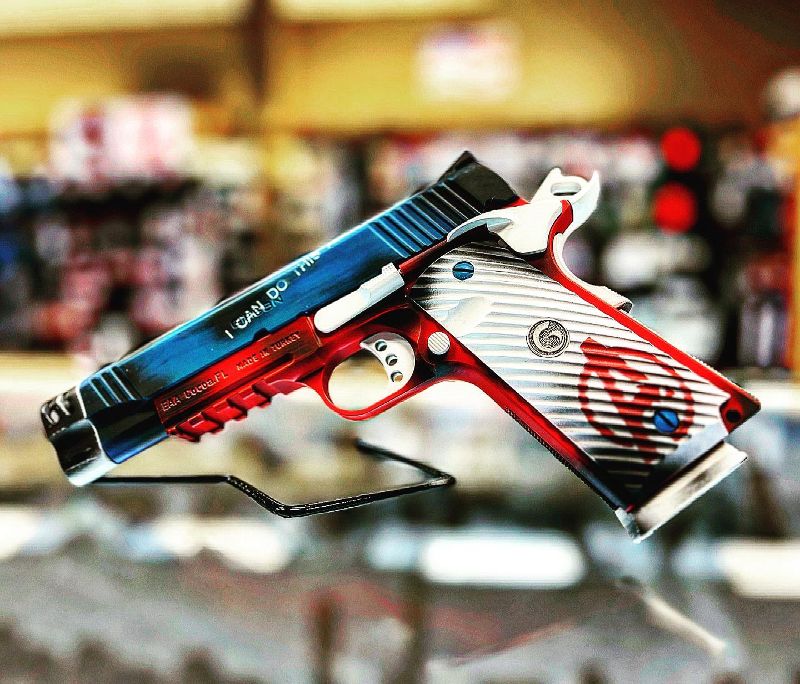 A red, white, and black handgun.