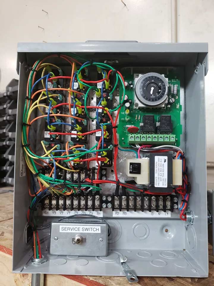 An HVAC unit sits open, revealing wires and hardware inside.