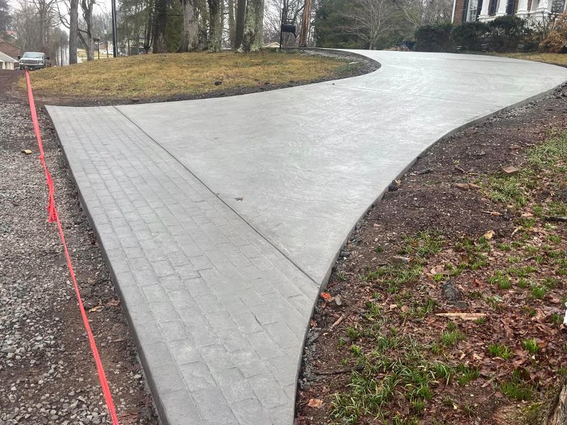A curved driveway with a brick edge at the bottom is roped after completion of pouring.