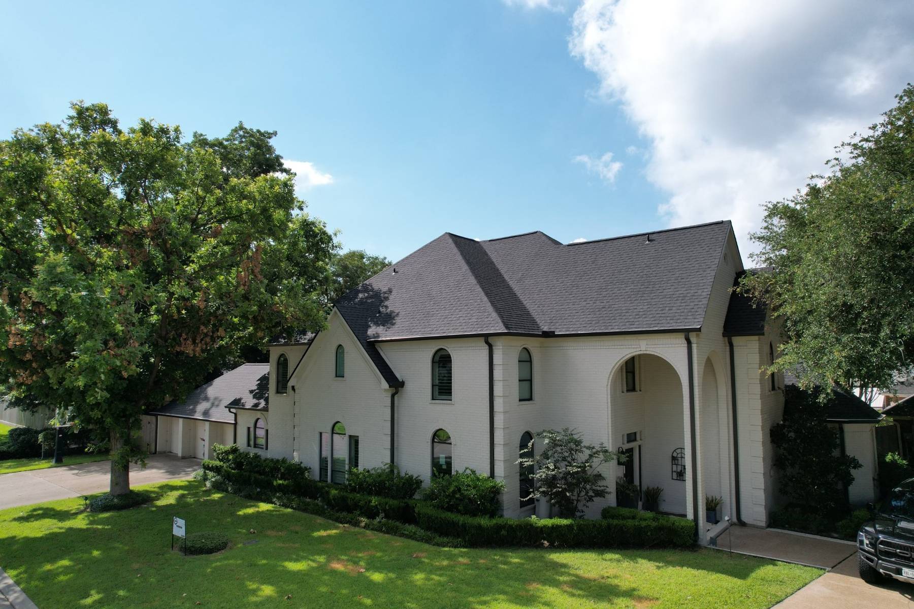 Overhead view of commercial building with grey shingles on roof.