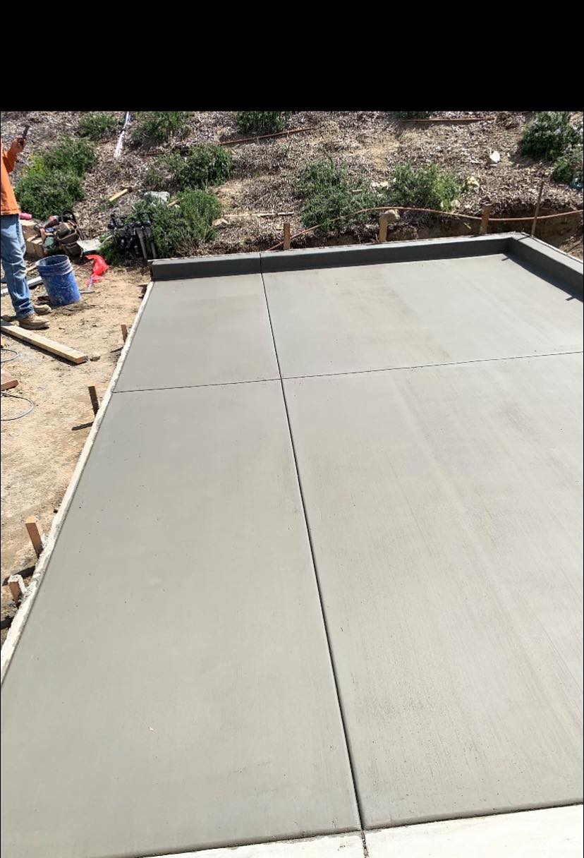 A freshly poured concrete patio with raised edge.