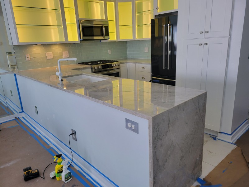 A kitchen island with a gray quartz countertop.