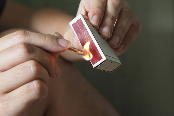 hands striking a match