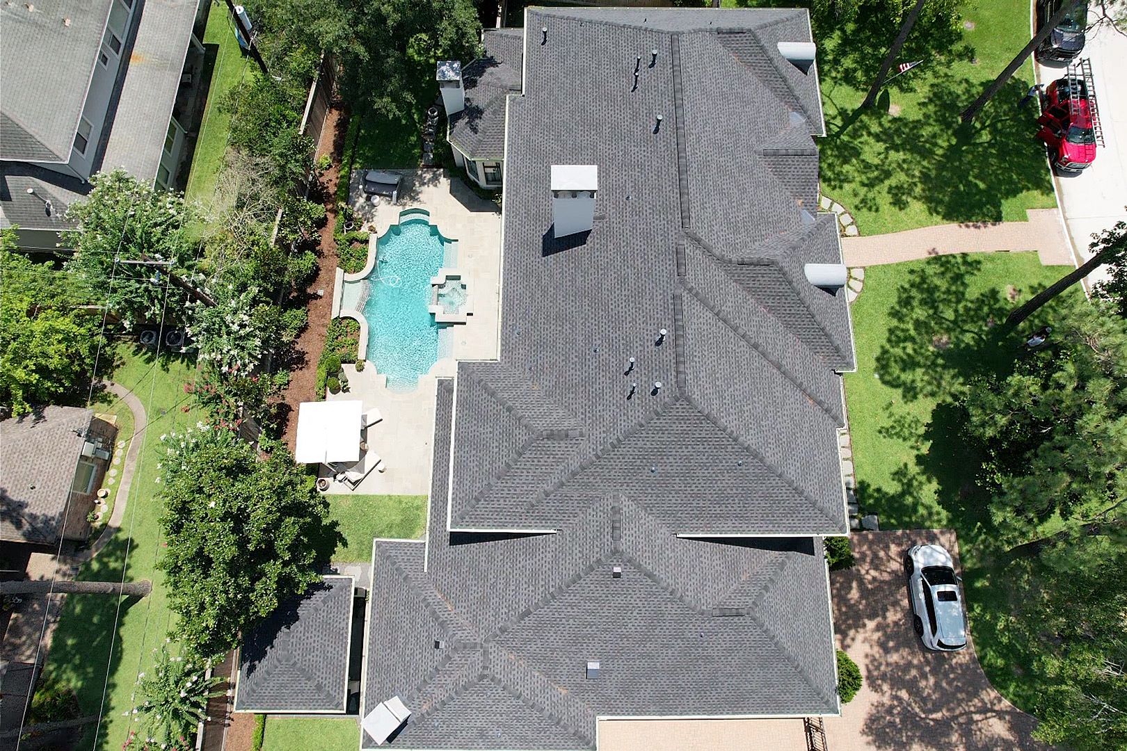 Overhead view of multi-layered roof with tan shingles.
