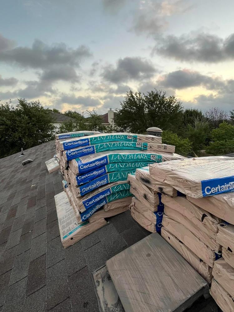 Stacks of Landmark shingles lie on a roof’s peak.