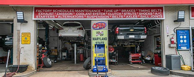 Two vehicles on lifts being repaired