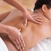Massage therapist massages their client's back.
