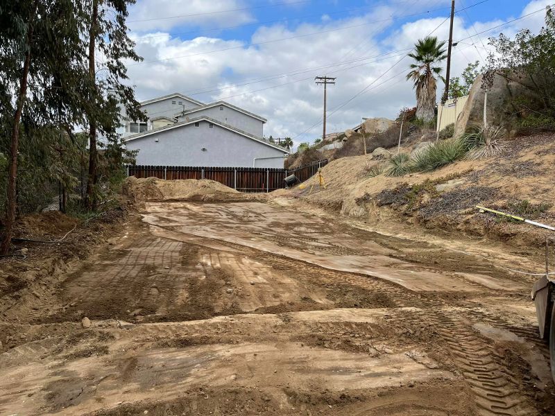 A hilly driveway is excavated, waiting for concrete to be poured.