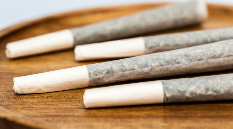 Pre-rolled marijuana cigarettes, or joints, on a wooden surface