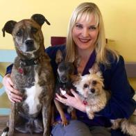 Stephanie Wilson posing with three dogs.