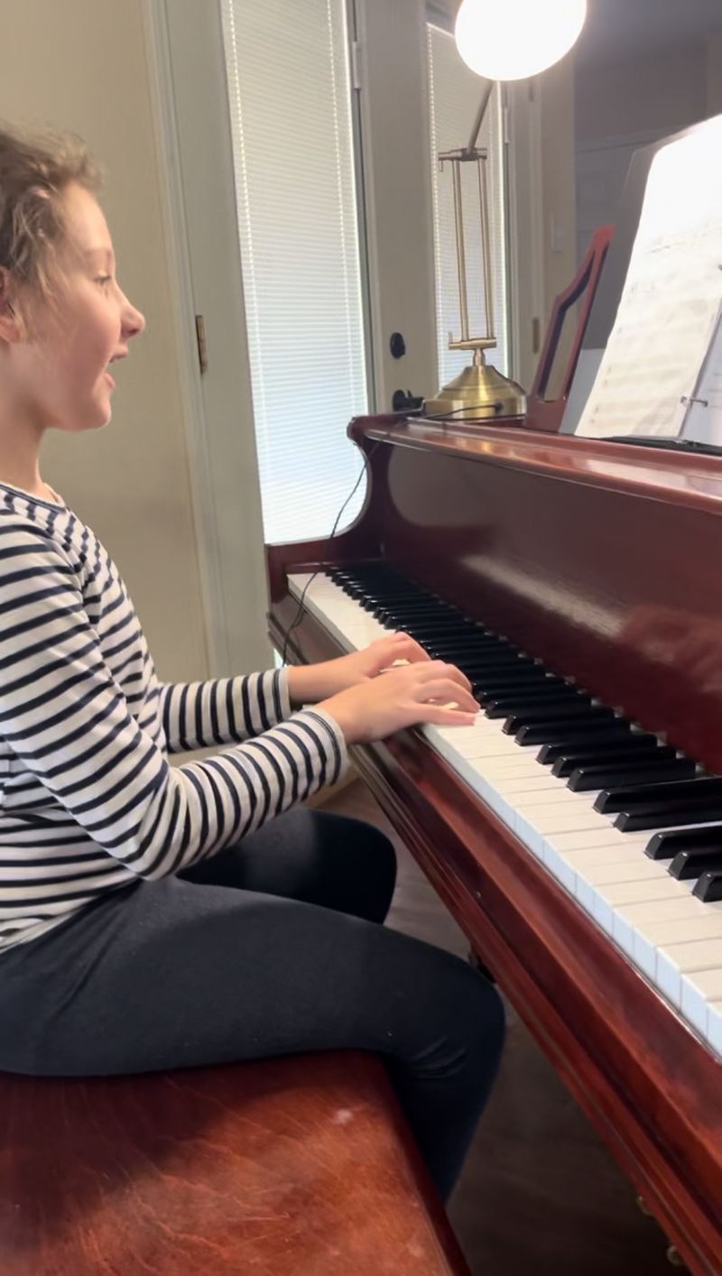 Young girl playing the pia along.