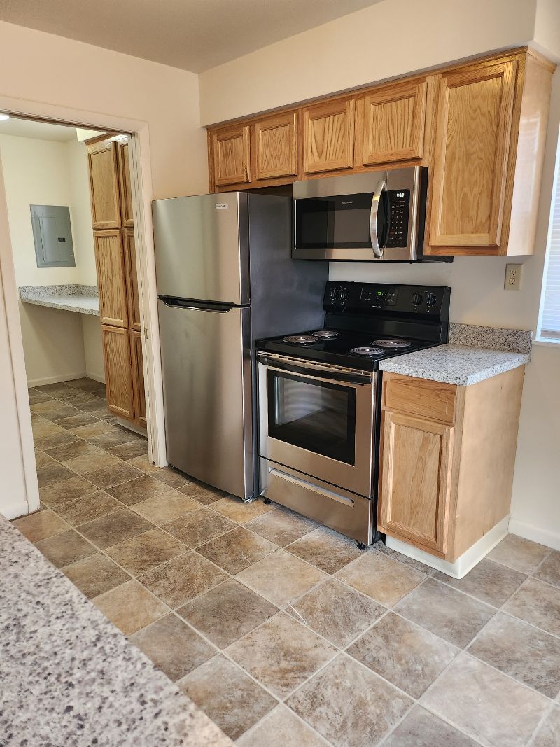 A modern kitchen with wooden cabinets and stainless steel appliances.