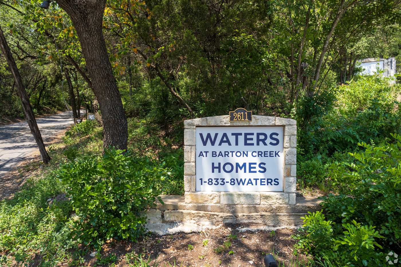 A welcome sign to Waters at Barton Creek Homes