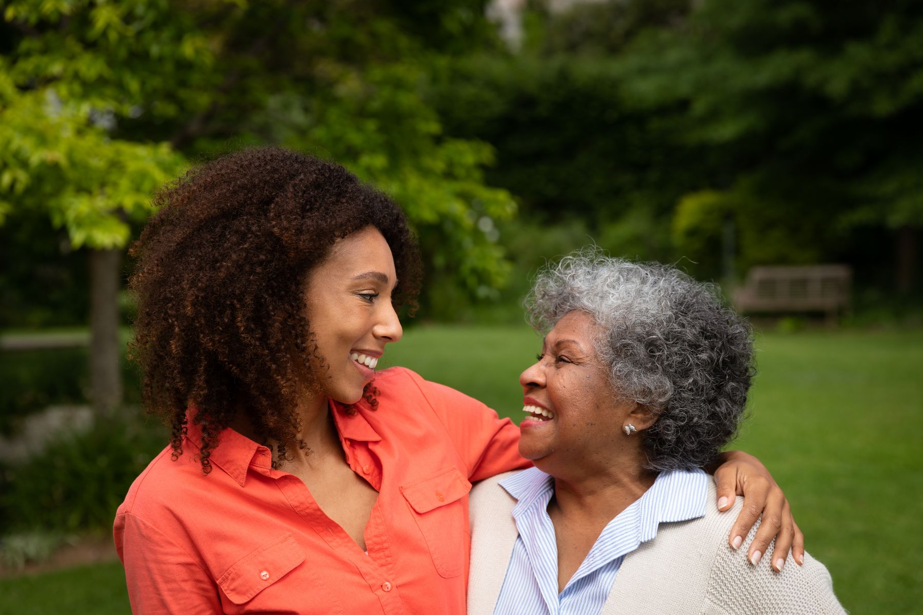 A mother and daughter smile at one another.