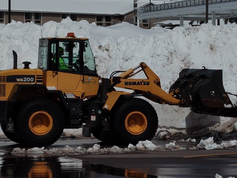 Snow plow removes heavy snow from driveway.