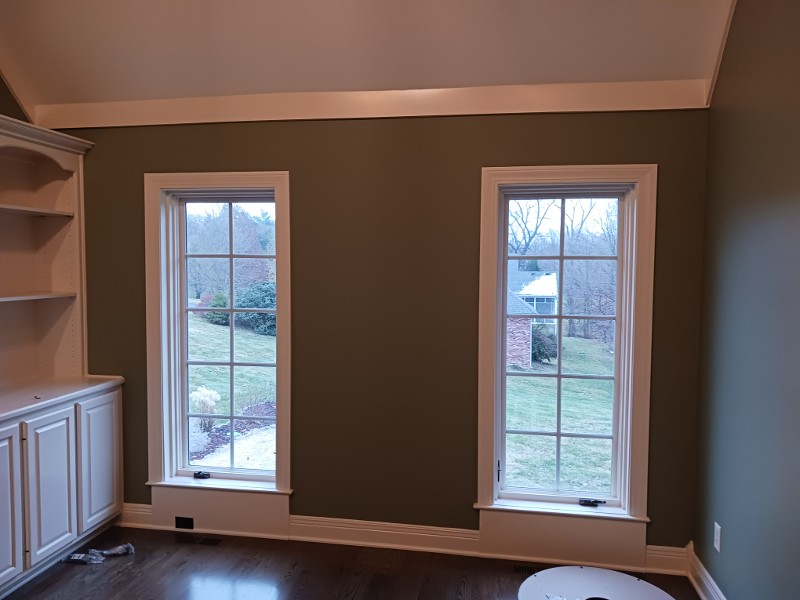 A living area with two large windows freshly painted.