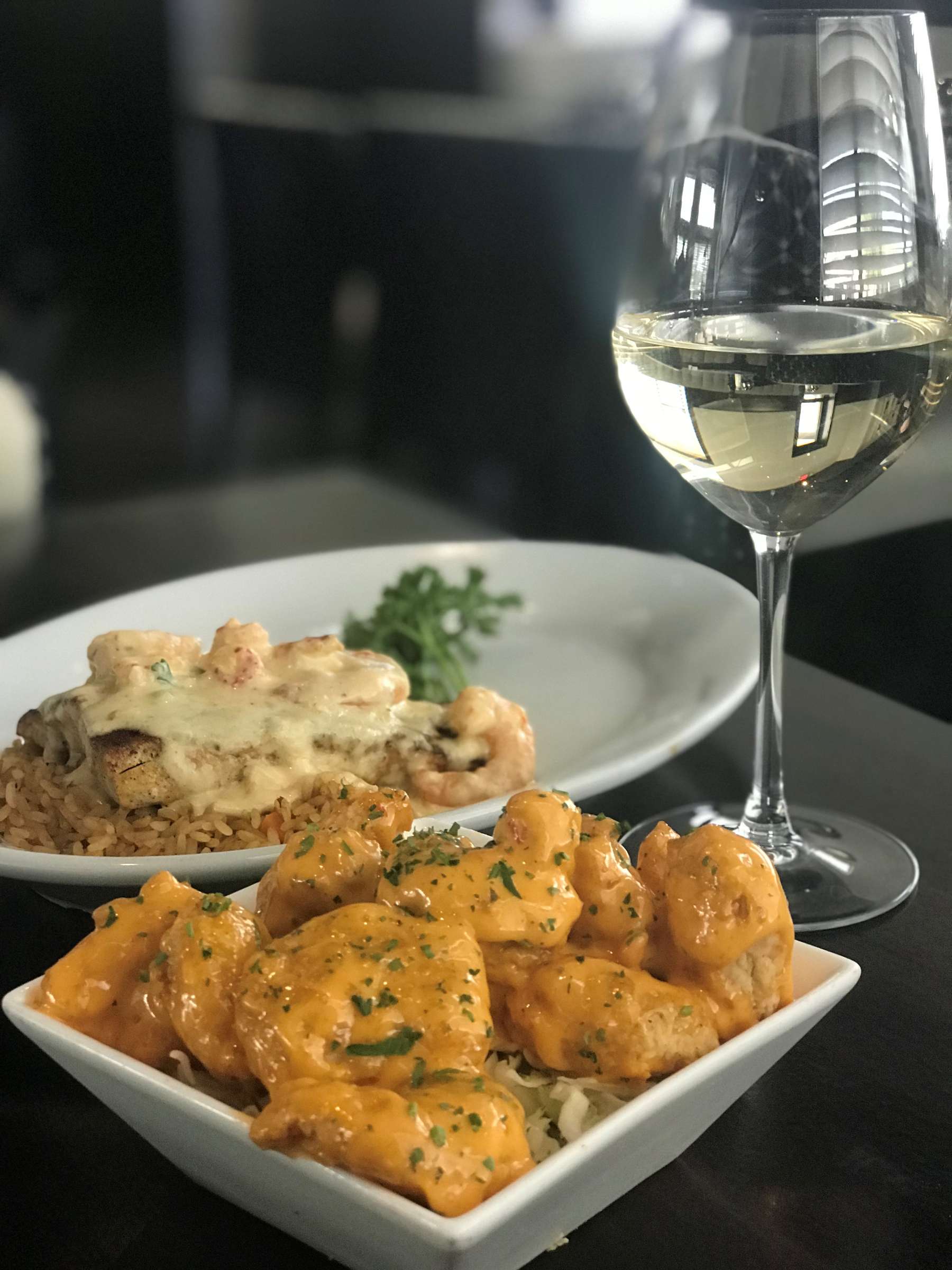 Firecracker shrimp served with a glass of wine.