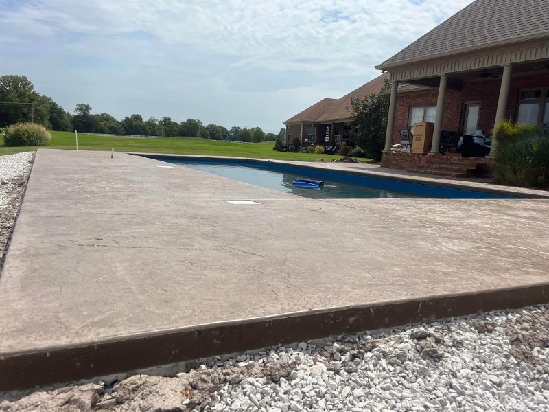 Stamped concrete surrounds a residential pool.