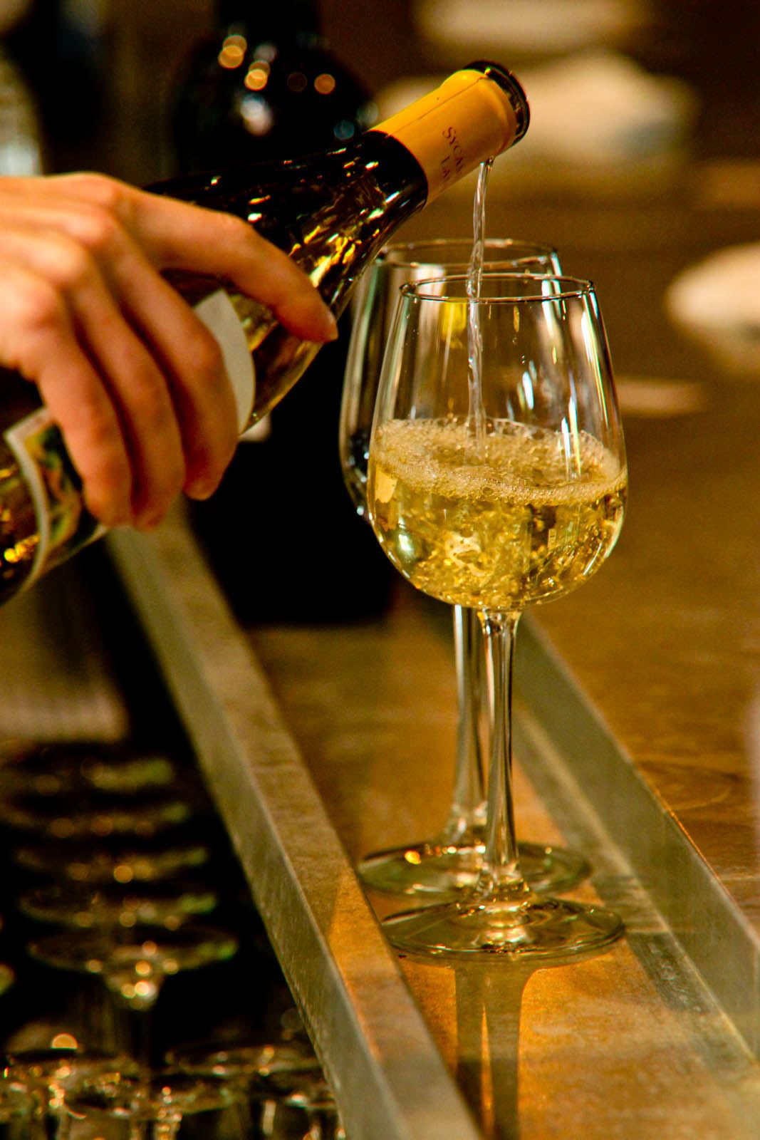 Close-up of champagne being poured into tall glasses